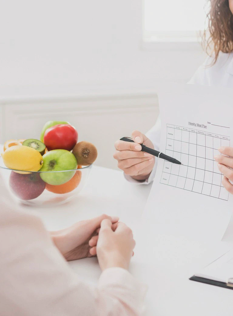 owoce w misce, długopis w dłoni